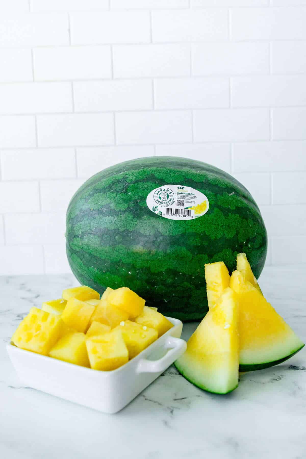 Whole yellow watermelon, sliced watermelon wedges, and cubed watermelon pieces showcasing the fruit’s golden interior and use as a sustainable summer snack.